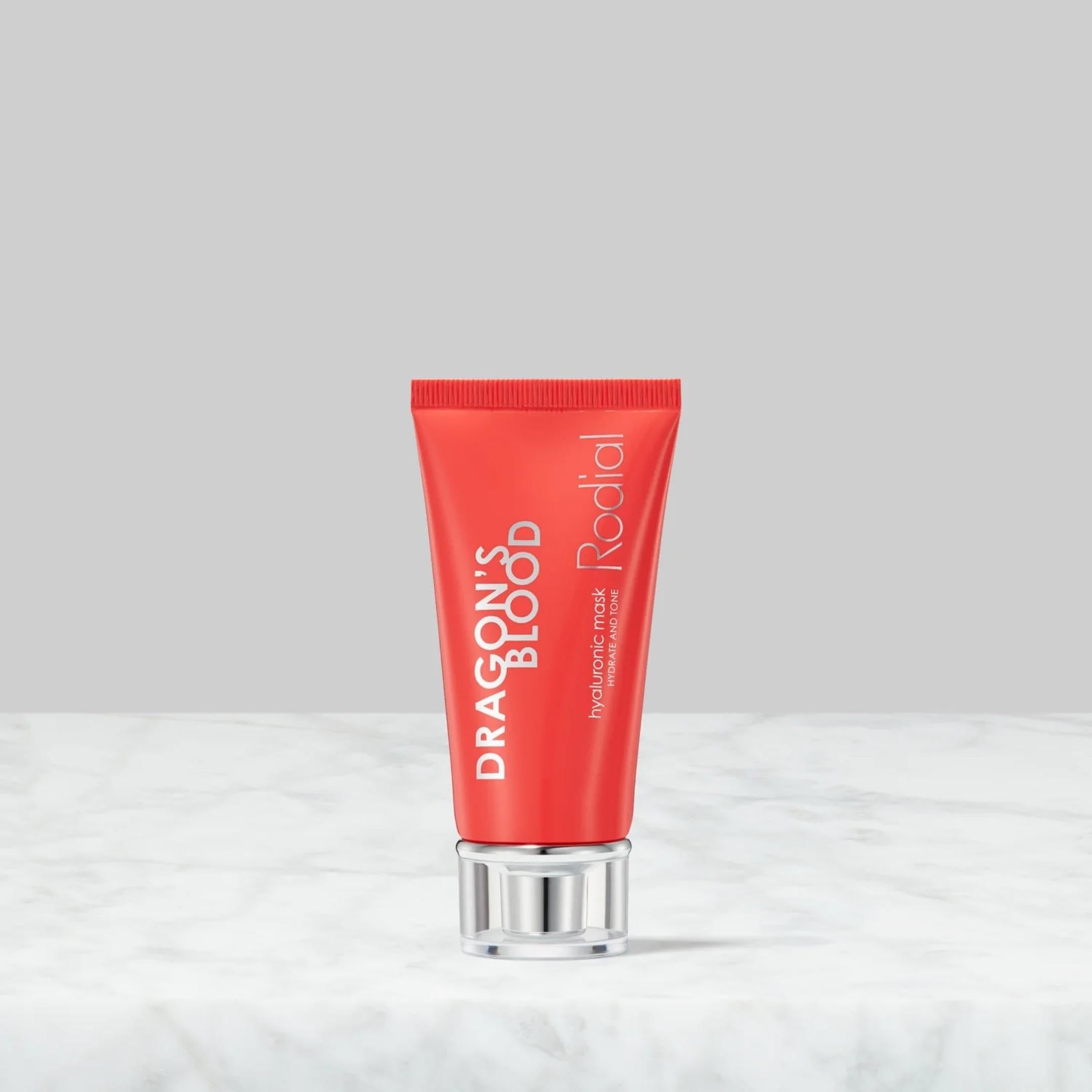 Rote Tube mit silbernem Verschluss. Aufschrift: DRAGON'S BLOOD, Rodial, Hyaluronic Mask. Auf Marmor.
