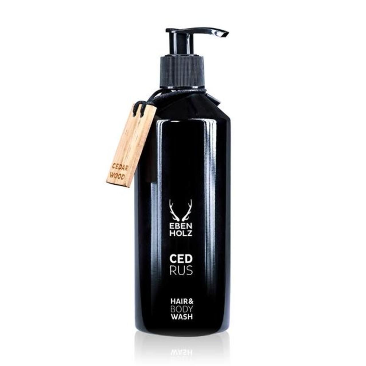 Schwarze Flasche mit Pumpe. Aufschrift: Ebenholz Cedrus Hair & Body Wash. Holzanhänger mit "Cedar Wood".