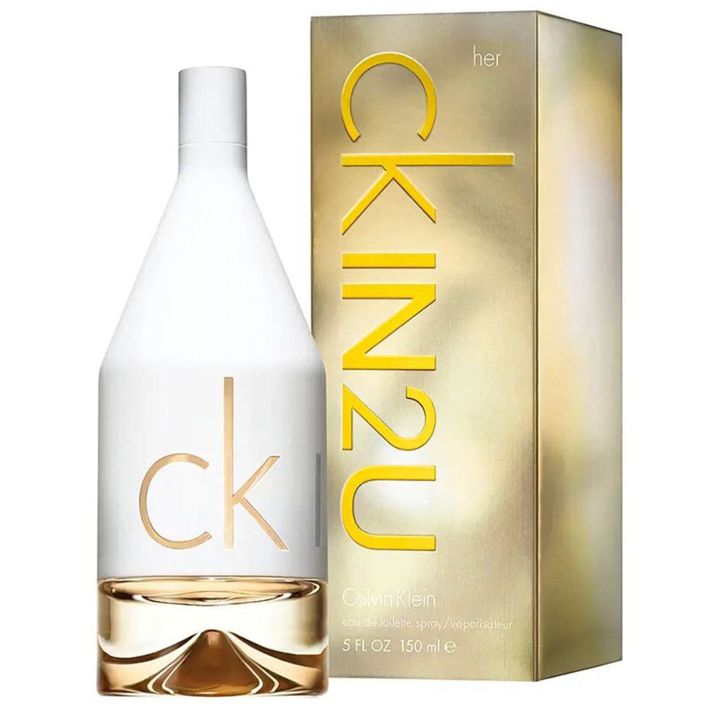 Parfümflasche neben einer goldenen Verpackung mit 'CK IN2U HER'-Aufschrift.