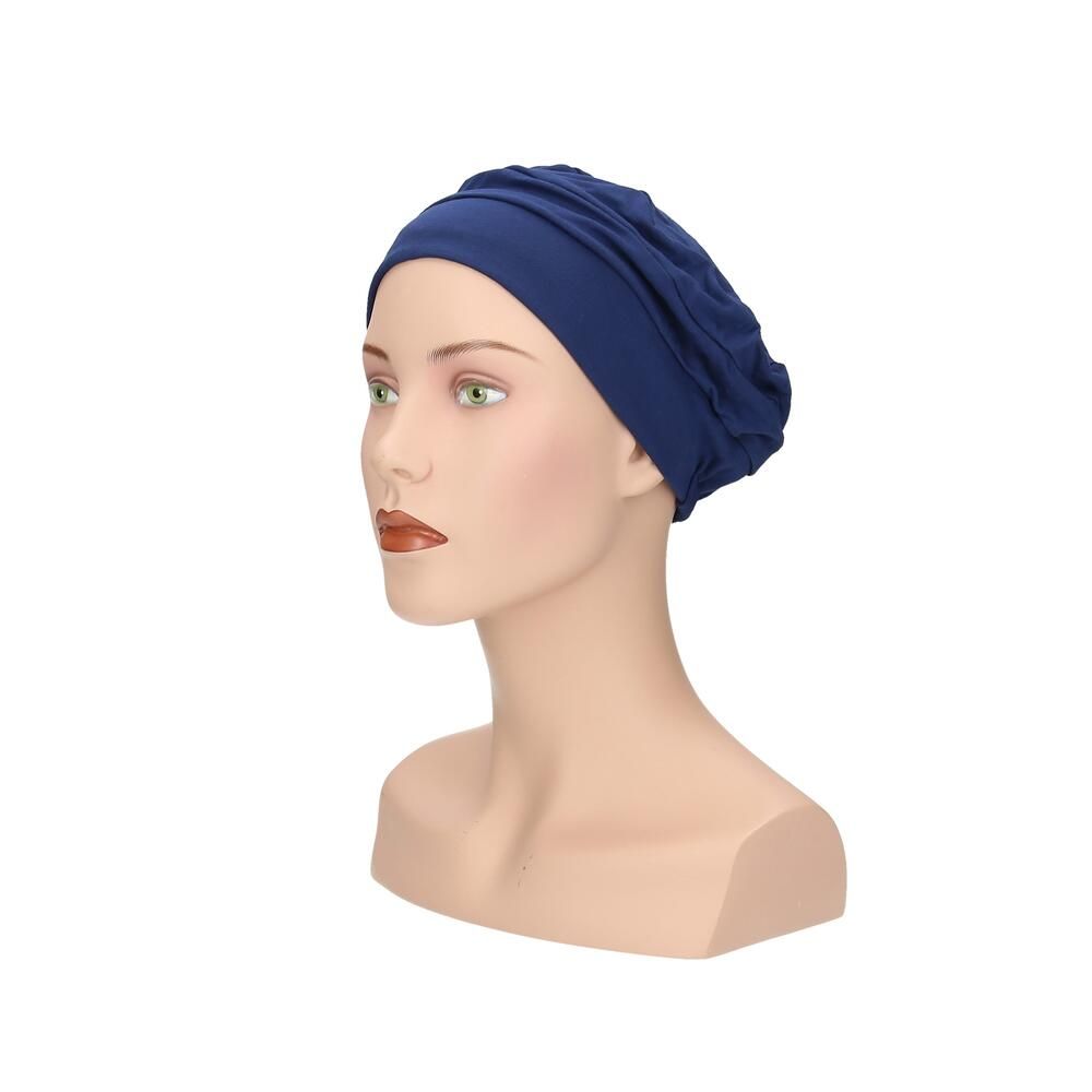 Blauer Turban auf Büste. Stoffhaube mit geraffter Struktur. Seitenansicht.