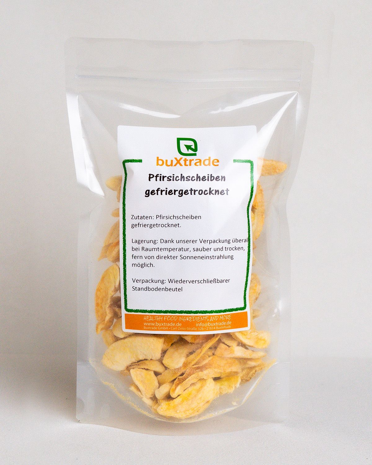Transparente Verpackung mit getrockneten Pfirsichscheiben. Weißes Etikett mit Text. Wiederverschließbar.