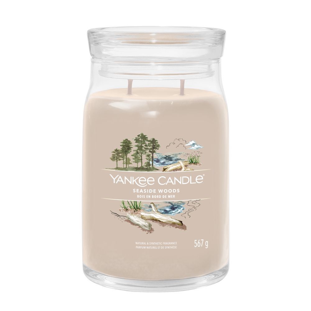 Glasbehälter mit Deckel, cremefarbenem Inhalt und Etikett. Aufschrift: Yankee Candle Seaside Woods, 567 g.