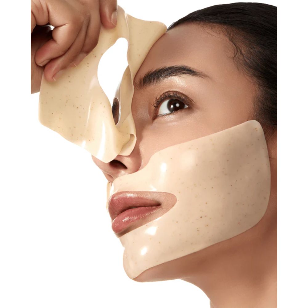 Gesicht mit angepasster Anua Rice 70 Glow Collagen Maske. Eine Maske wird abgezogen. Maske ist beige.