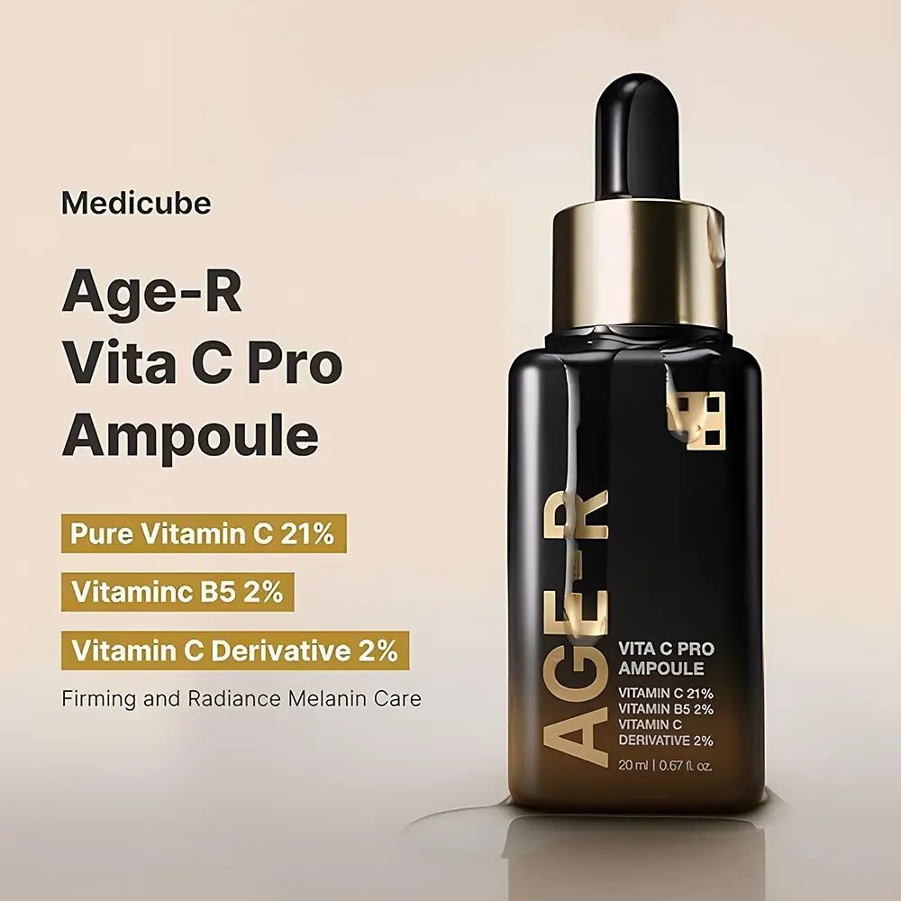 Serumflasche mit goldfarbenem Deckel und Pipette. Aufschrift AGE-R Vita C Pro Ampoule. Enthält Vitamin C. Hintergrund mit Text.