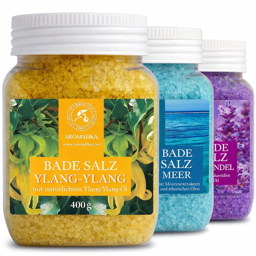 Drei Gläser Badesalz. Gelb, blau und lila. Etiketten mit Produktnamen und Logo. Gelbes Glas: Ylang-Ylang. Blau: Meeresbrise. Lila: Lavendel.