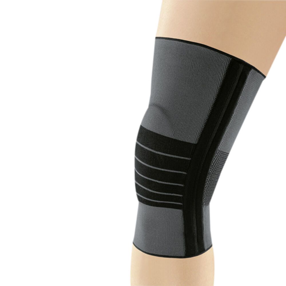 Graue Kniebandage JuzoFlex® Genu 500. Schwarze Verstärkungen und Streifen. Auf einem Bein getragen.