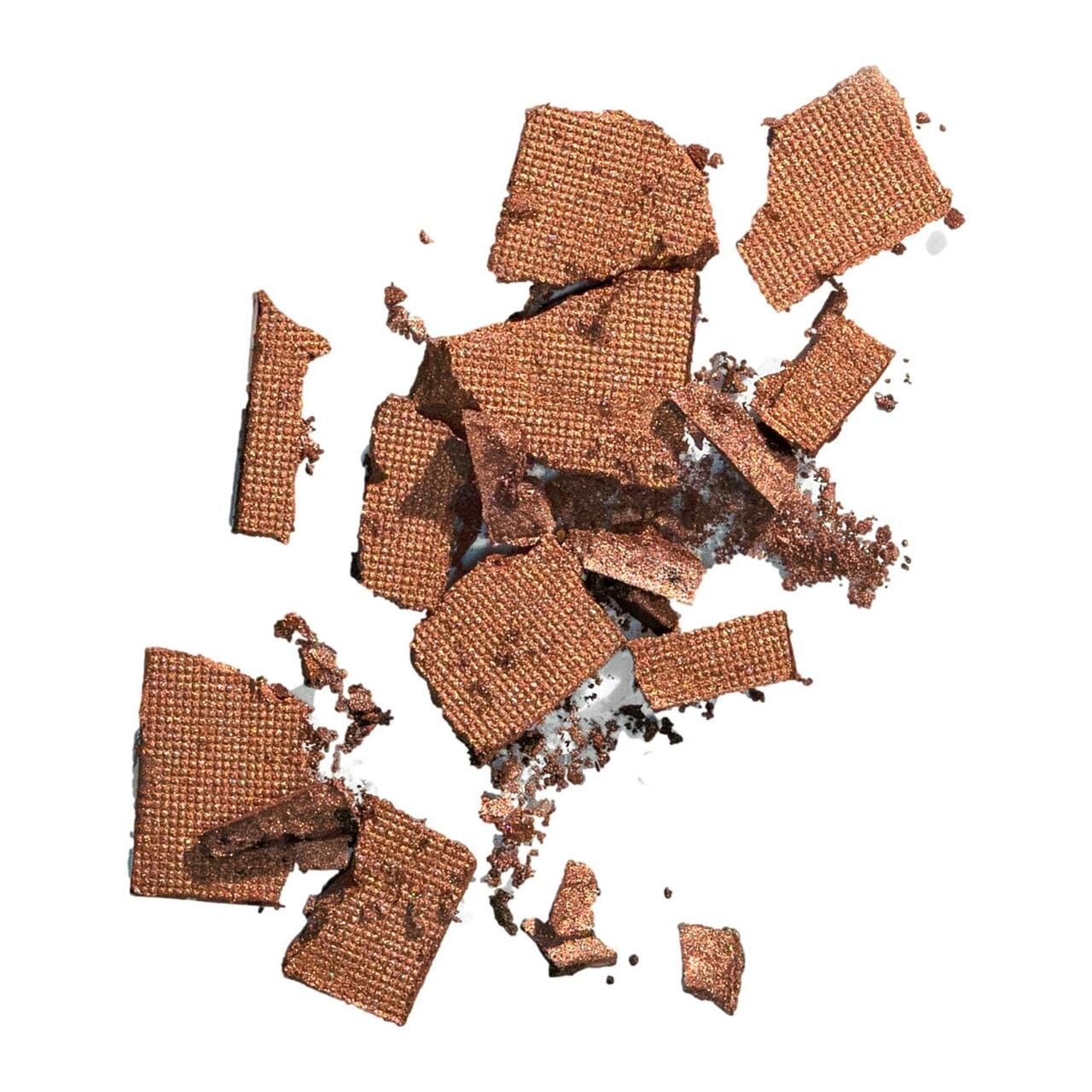 Zerkleinerte, goldfarbene Color Wow Root Cover Up-Puderstücke. Auf weißem Hintergrund.