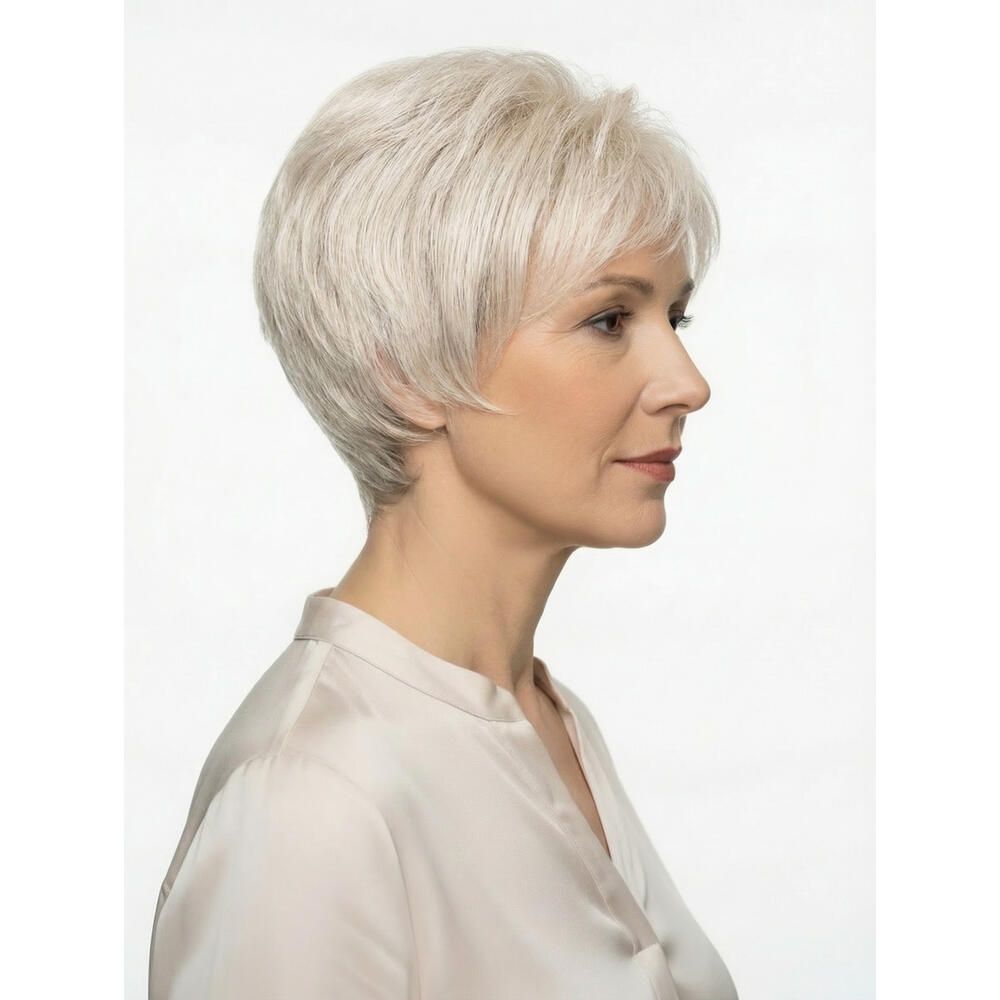 Frau mit Perücke, hellgraues Haar, kurzer Schnitt. Trägt helles Hemd. Seitenansicht.