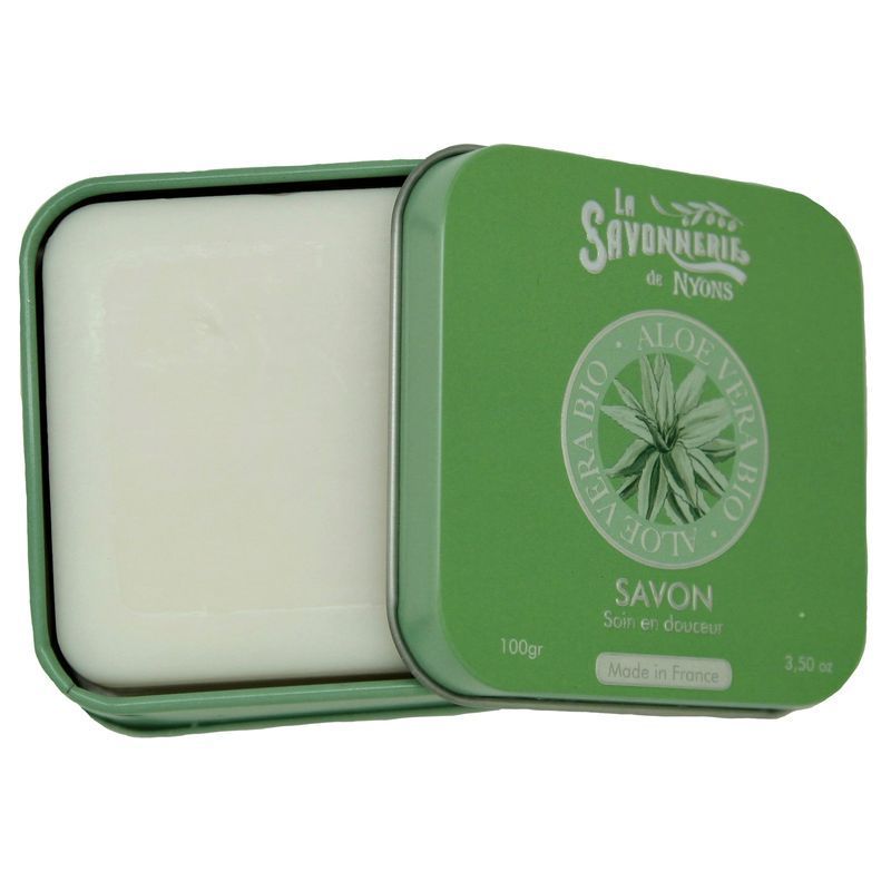 Geöffnete grüne Metallbox mit Seife. Seife quadratisch, hell. "La Savonnerie de Nyons" und "Savon" auf der Box.