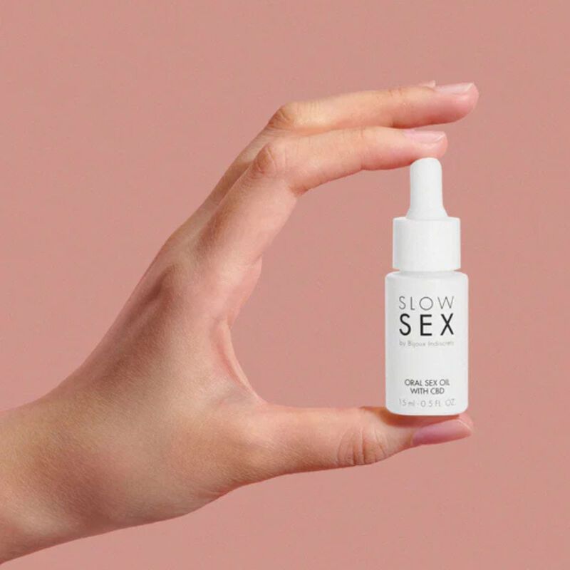 Kleine weiße Flasche mit Tropfer, gehalten von einer Hand. Aufschrift: SLOW SEX, Oral Sex Oil with CBD.