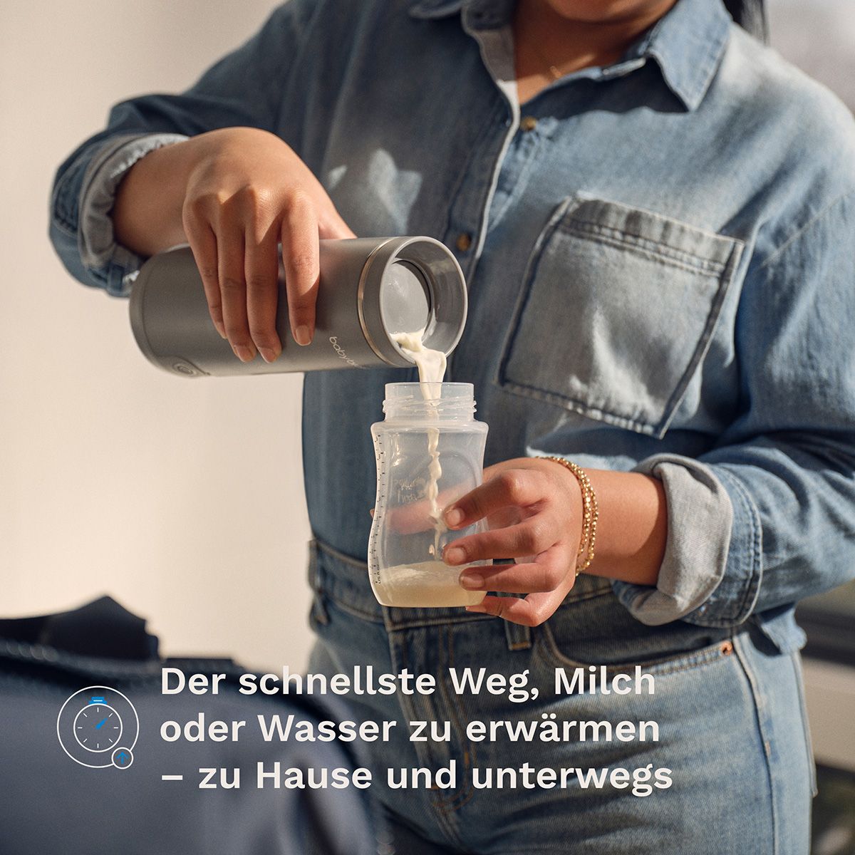 Grauer Tragbarer Muttermilch- & Wasserwärmer wird benutzt, um Milch in eine Flasche zu gießen.