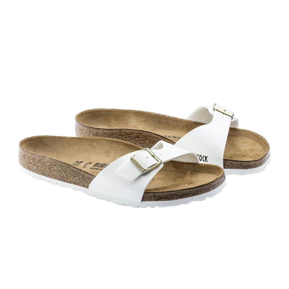 Paio di sandali bianchi con fibbie. Plantare in sughero, tomaia bianca. Logo Birkenstock visibile.