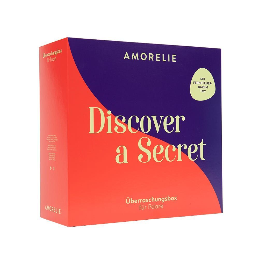 Rote und violette Box mit "AMORELIE Discover a Secret". Text: "Überraschungsbox für Paare". Mit Fernbedienung.