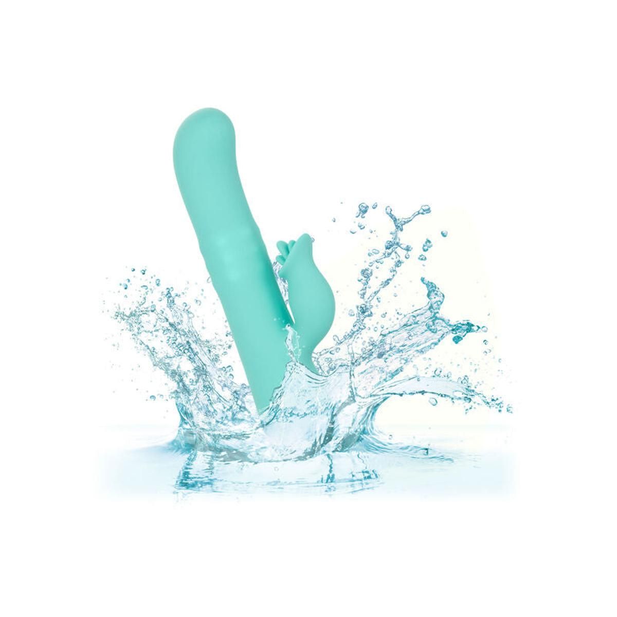 Türkisfarbener Vibrator im Wasser, umgeben von Wasserspritzern.