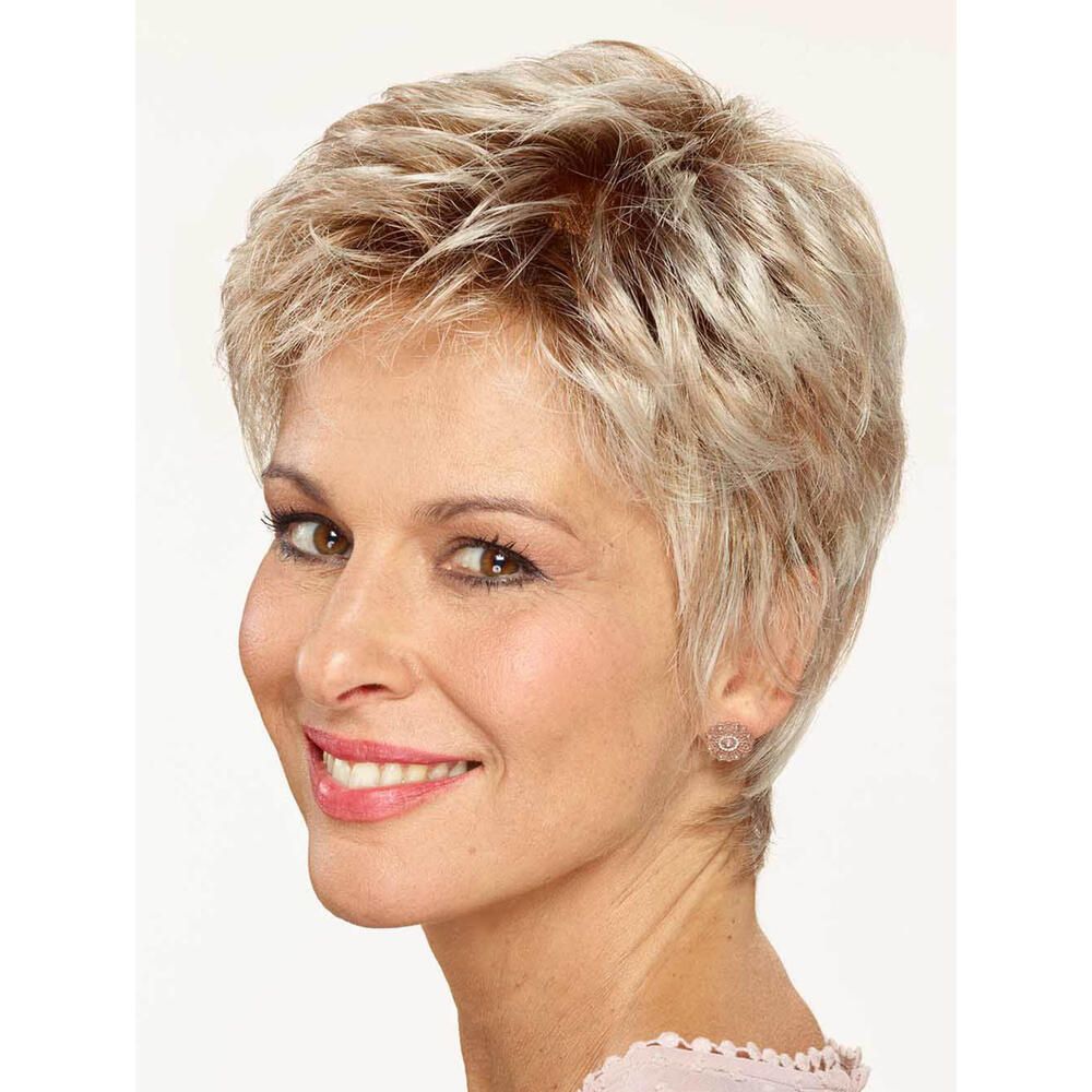 Kurzhaarperücke in Blondtönen. Frau mit Perücke, lächelnd. Ohrringe. Rosa Oberteil. Heller Hintergrund.