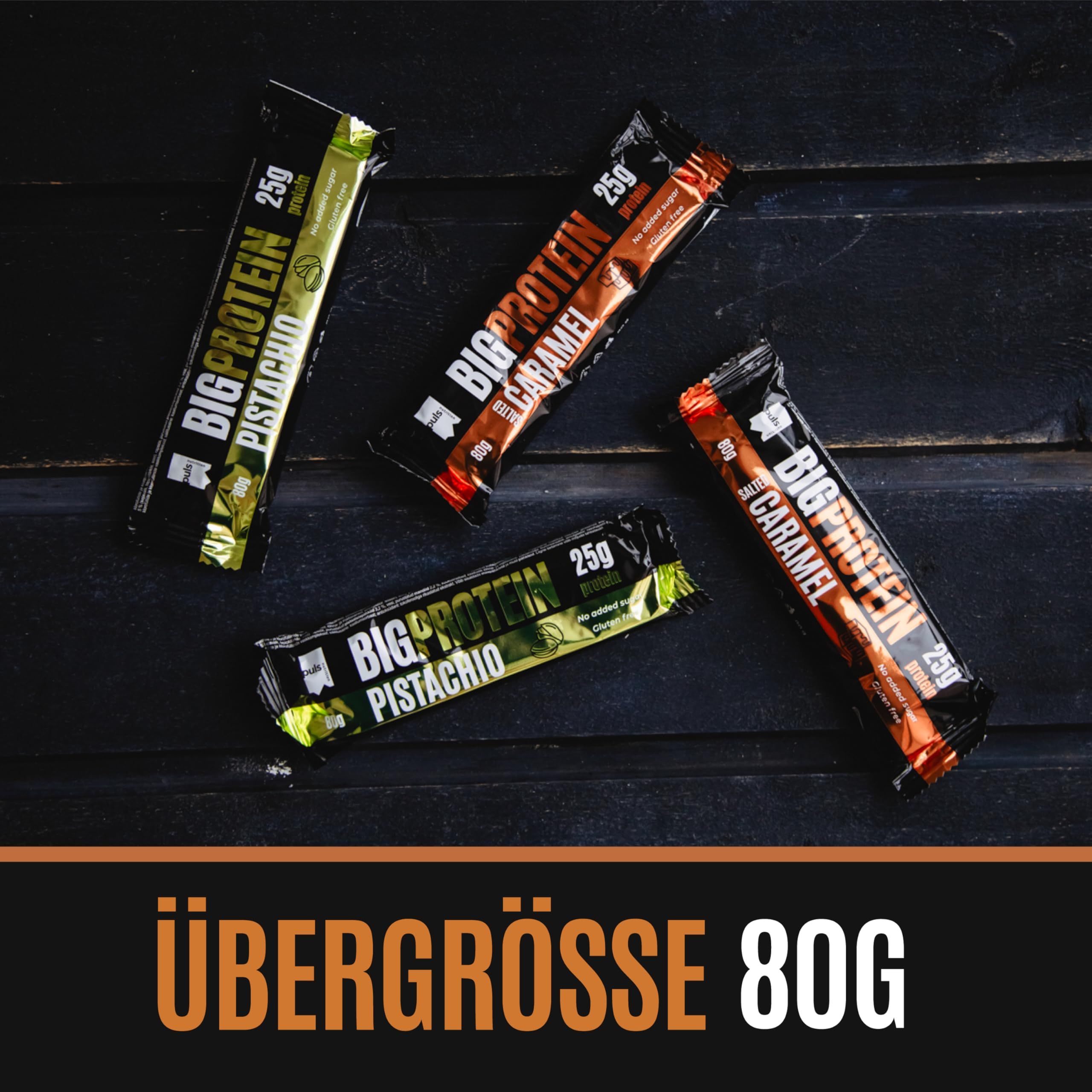 Vier Puls Nutrition Big Protein Riegel (Salted Caramel, Pistazie) auf dunklem Holzuntergrund. 80g Riegel.