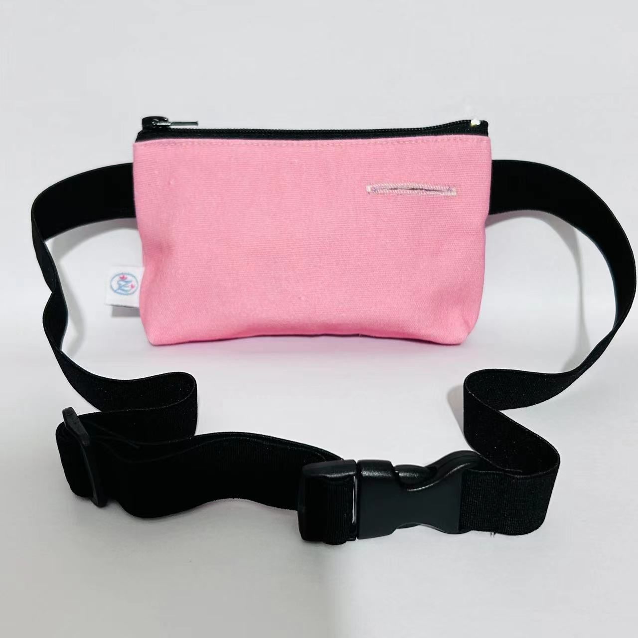 Rosa Tasche mit schwarzem Bauchband und Schnalle. Schwarzer Reißverschluss. Kleines Etikett.