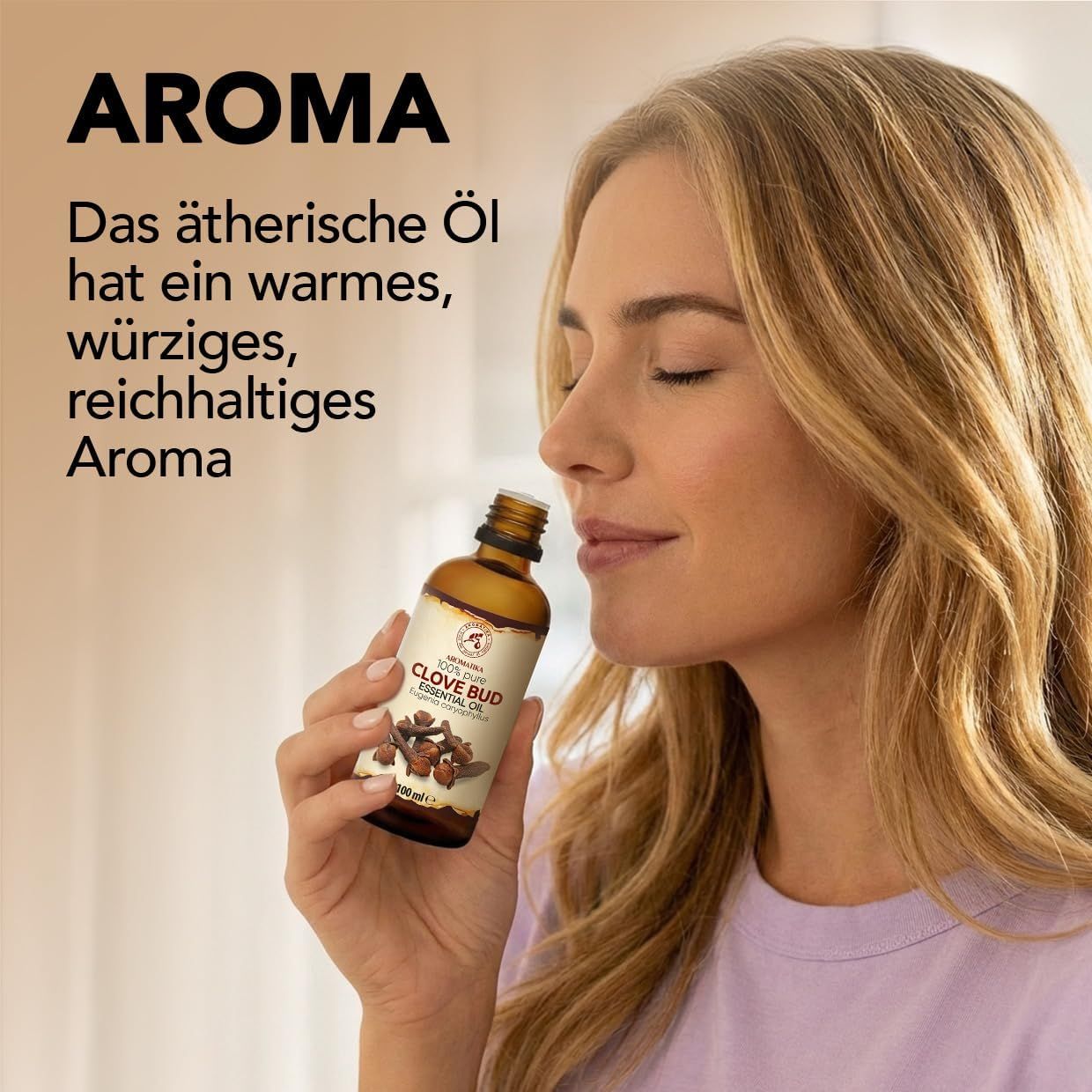 Frau riecht an einer Flasche Clove Bud Essential Oil.
