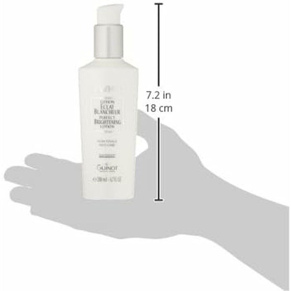 Weiße Flasche mit Pumpe, gehalten von einer Hand. Aufschrift NEWWHITE, LOTION ÉCLAT BLANCHEUR. 18 cm hoch.