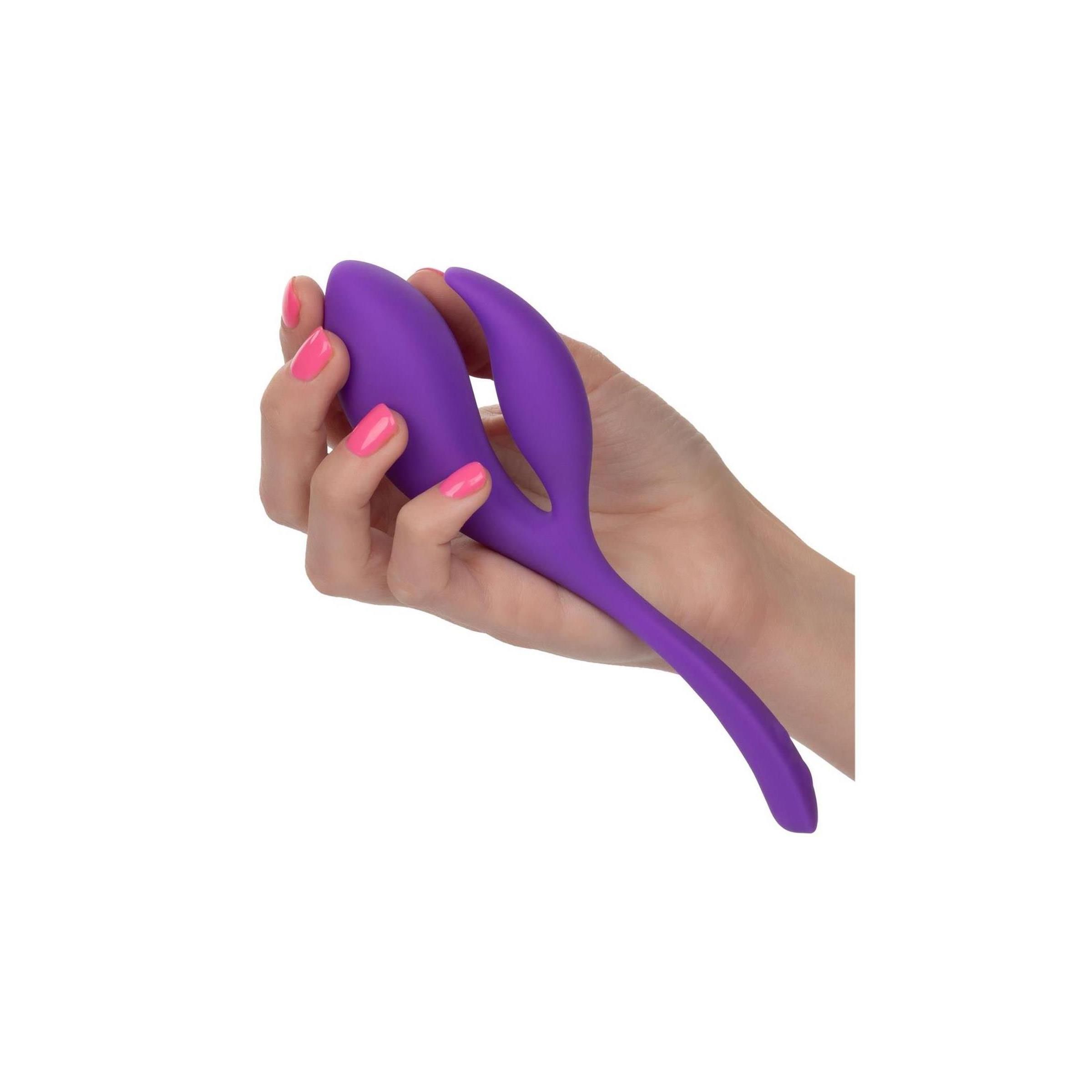 Lila Produkt in einer Hand gehalten. Rosa lackierte Fingernägel.