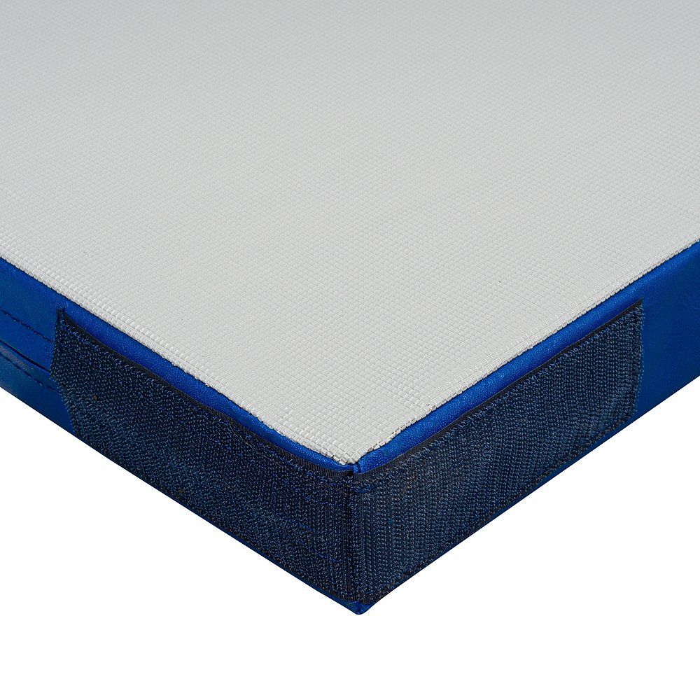 Blau-weiße Turnmatte, Detailansicht. Blaue Kanten, Klettverschluss. Weiße, strukturierte Oberfläche. Eckansicht.