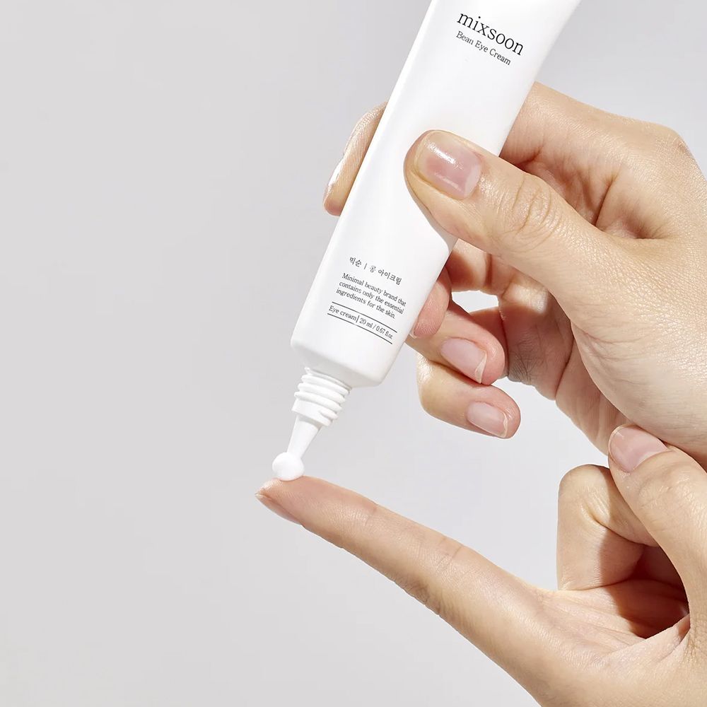 Hand gibt Mixsoon Bean Eye Cream auf Finger.