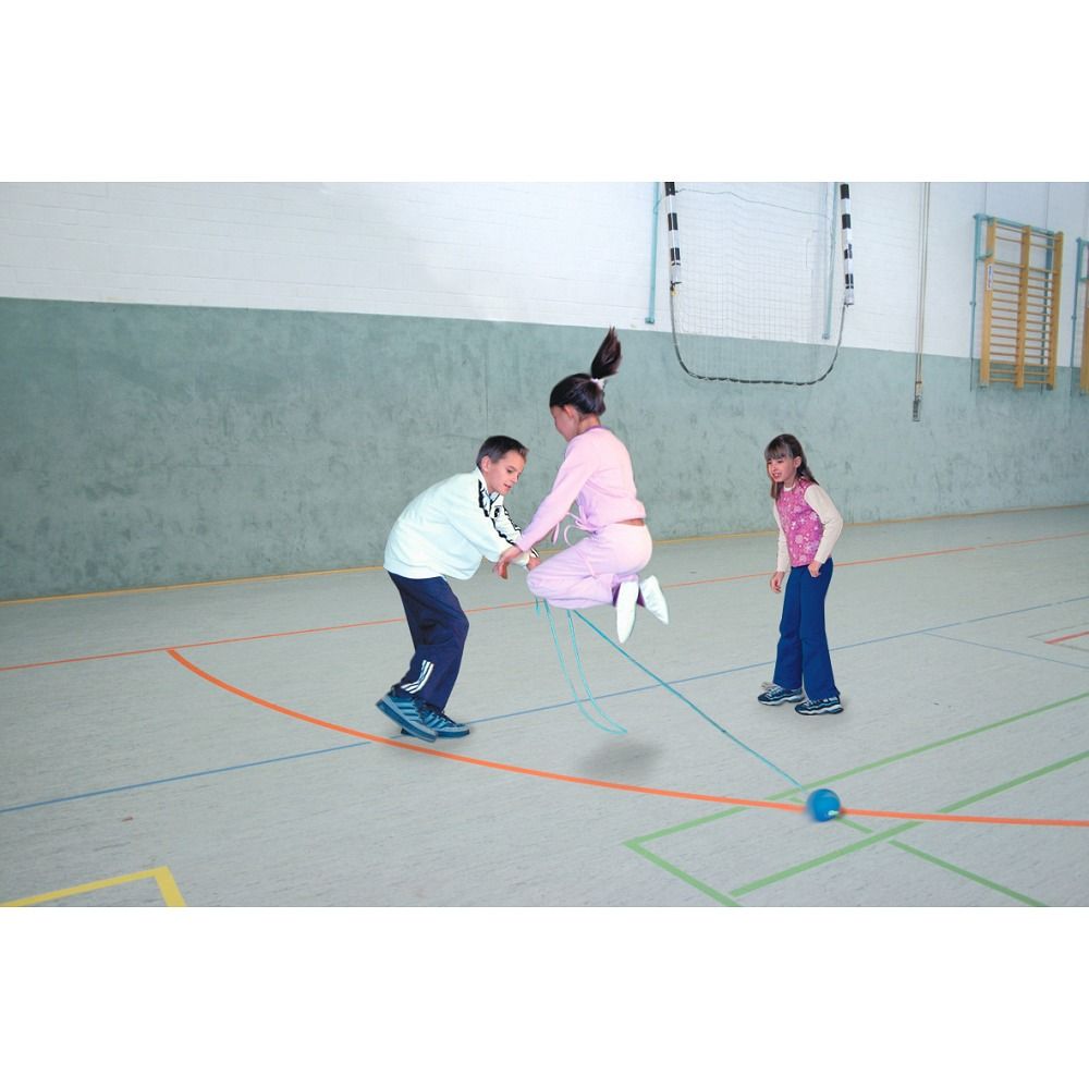 Kinder spielen mit einem blauen Schleuderspringseil. Ein Mädchen springt, zwei andere halten das Seil.