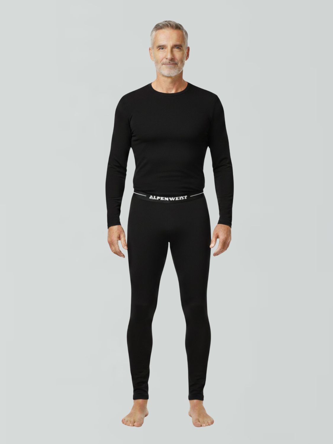 Mann in schwarzer Langarmshirt und langer Unterhose aus Merinowolle mit ALPENWERT-Bund.
