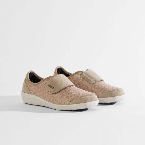 Beigefarbene Damenschuhe mit Klettverschluss und dezentem Muster.