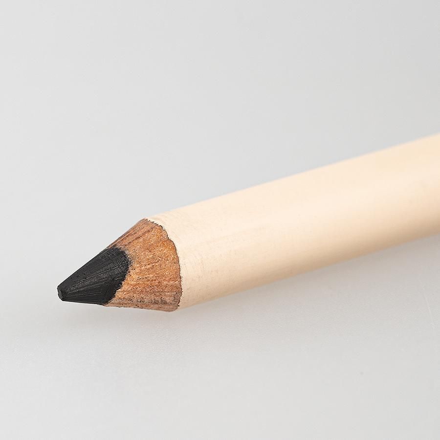 Nahaufnahme der Spitze eines Kajalstifts. Schwarze Spitze, Holzschaft, helle Farbe.