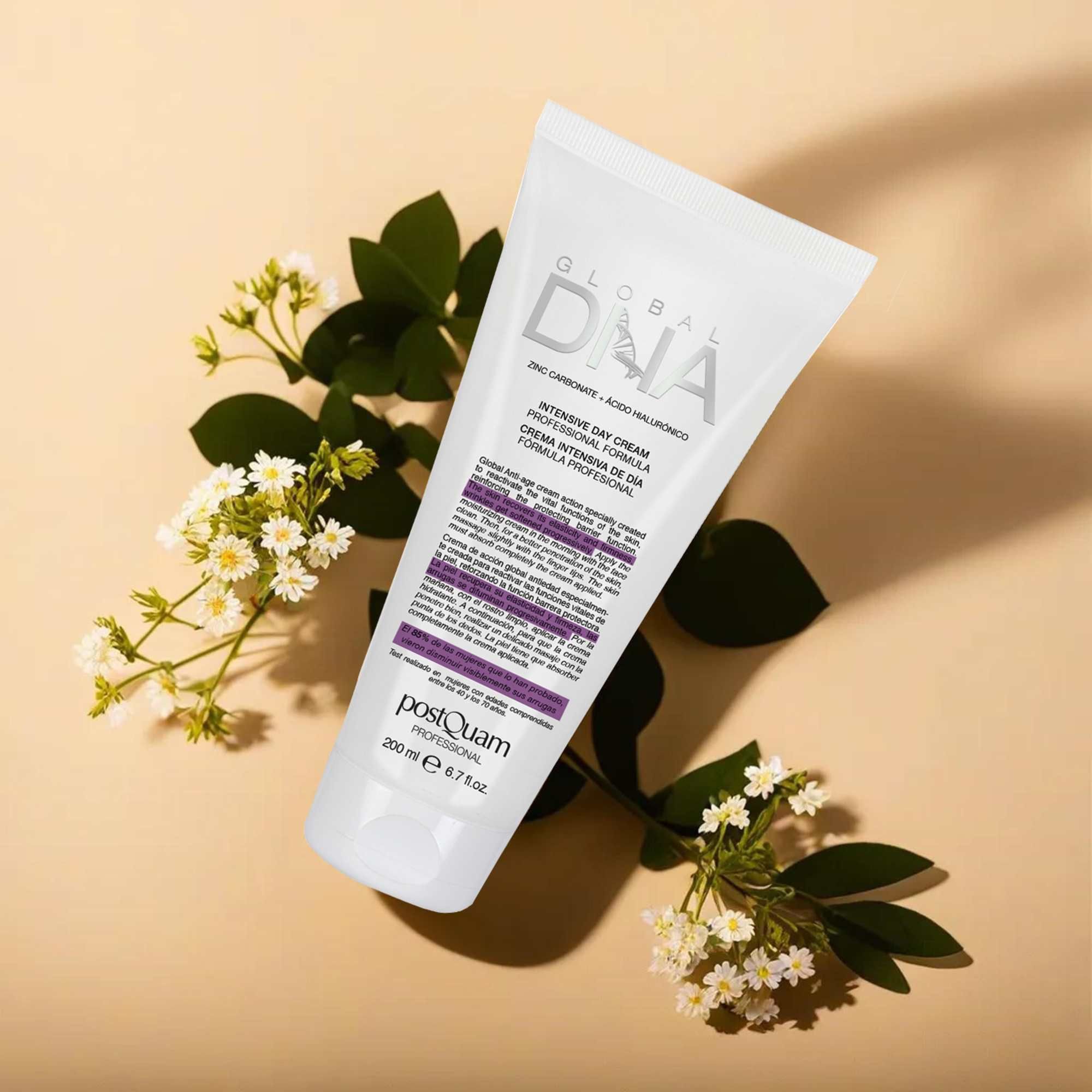Weiße Tube mit Produkttext, umgeben von Blüten und Blättern. Aufschrift: Global DNA, Intensive Day Cream. Marke: Postquam. Volumen: 200 ml.