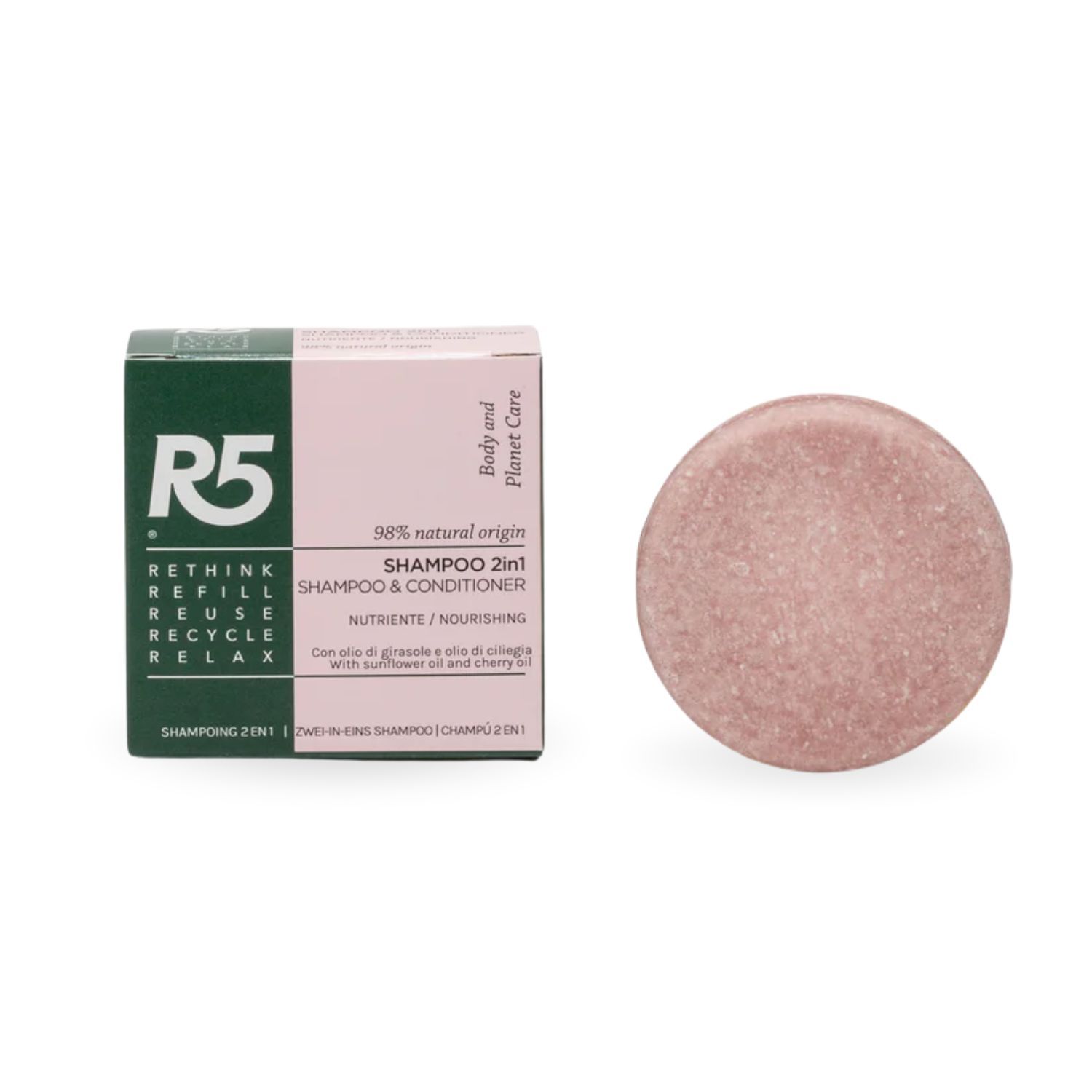 Rundes, festes Shampoo neben Verpackung. Verpackung mit Text: Shampoo 2in1, 98% natural origin.