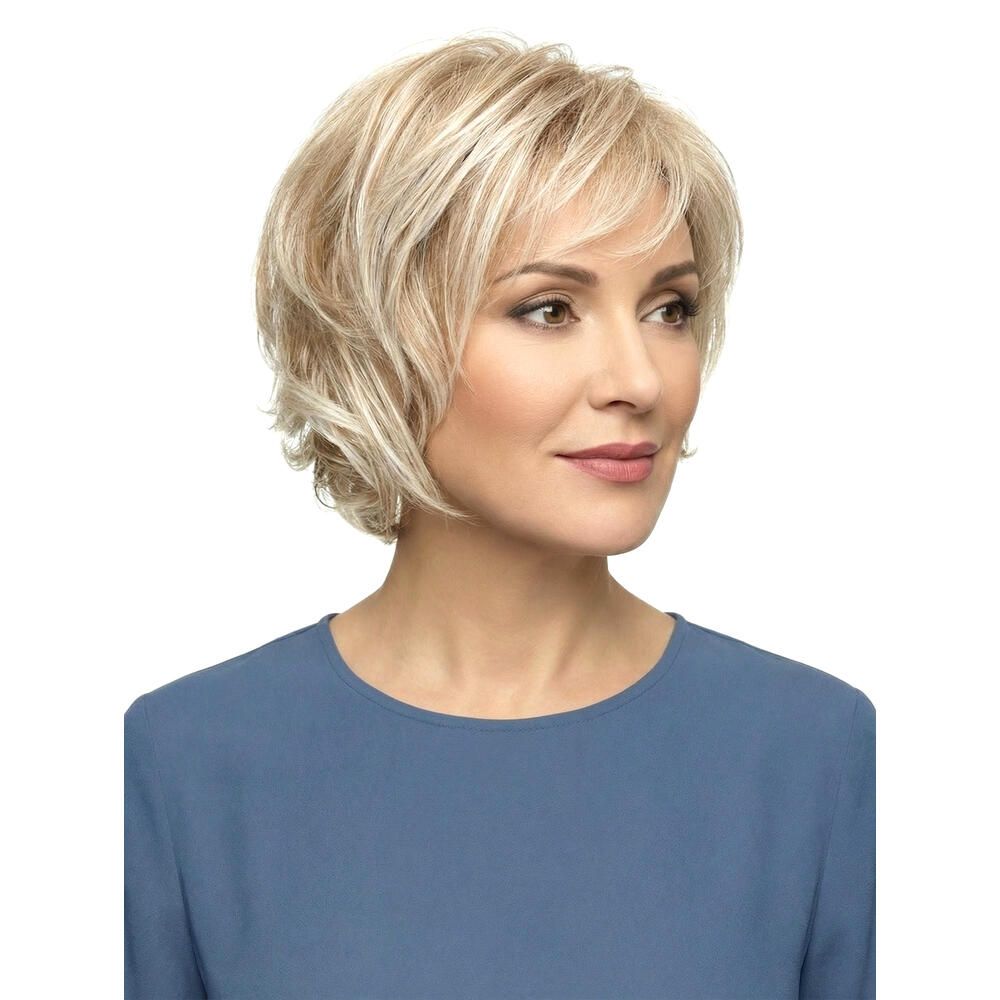 Blonde Perücke mit kurzem, gewelltem Schnitt. Dreiviertelansicht einer Frau mit blauem Oberteil.