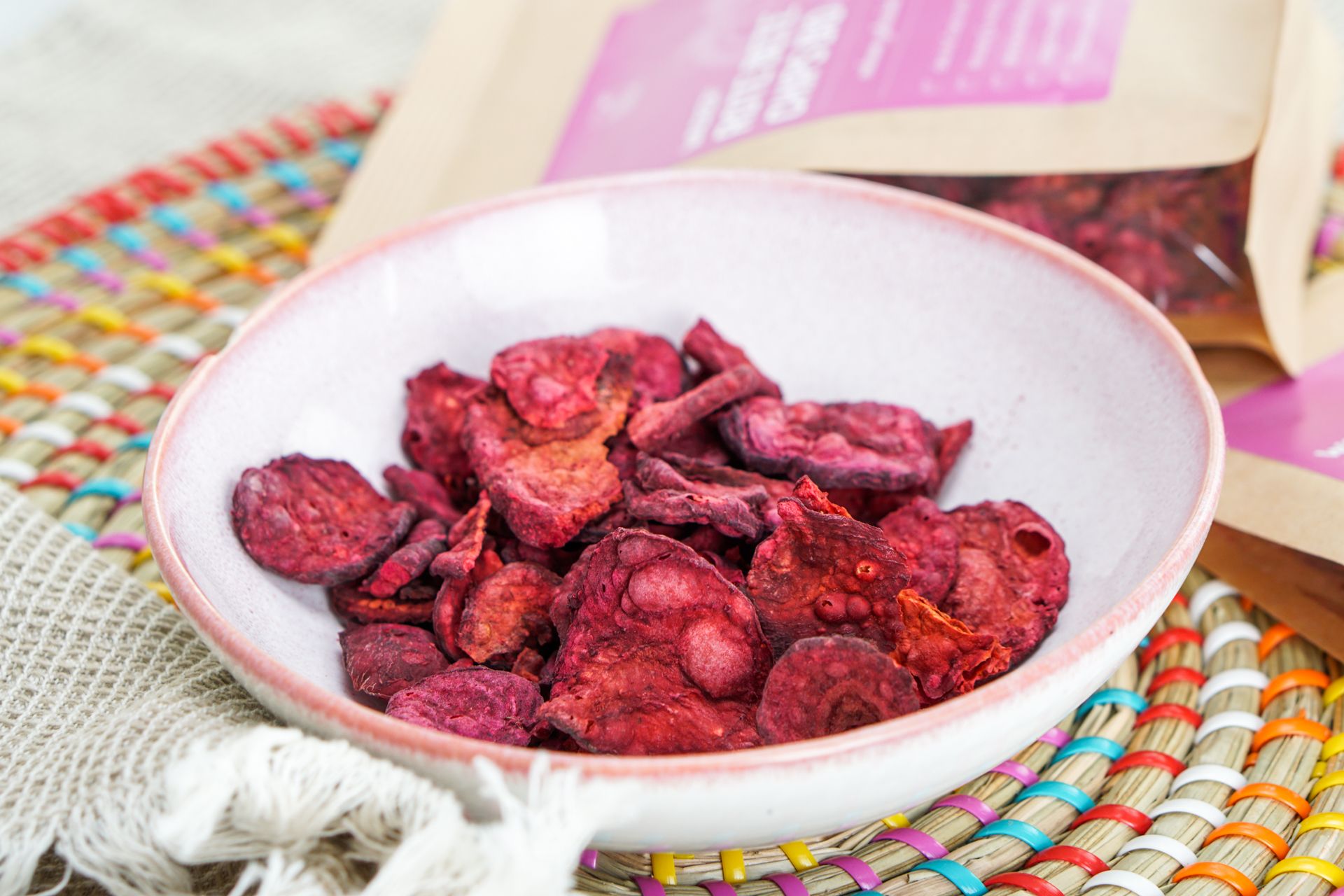 Rote Bete Chips in einer Schale. Chips sind rot und unregelmäßig geformt. Mehrere Chips in einer Schale.