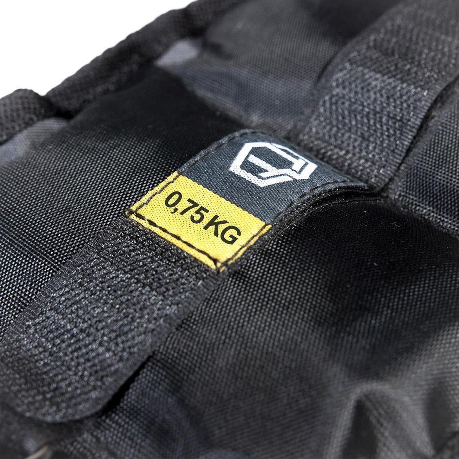 Schwarze Gewichtsmanschette mit gelbem Etikett. Aufschrift: 0,75 KG. Logo.