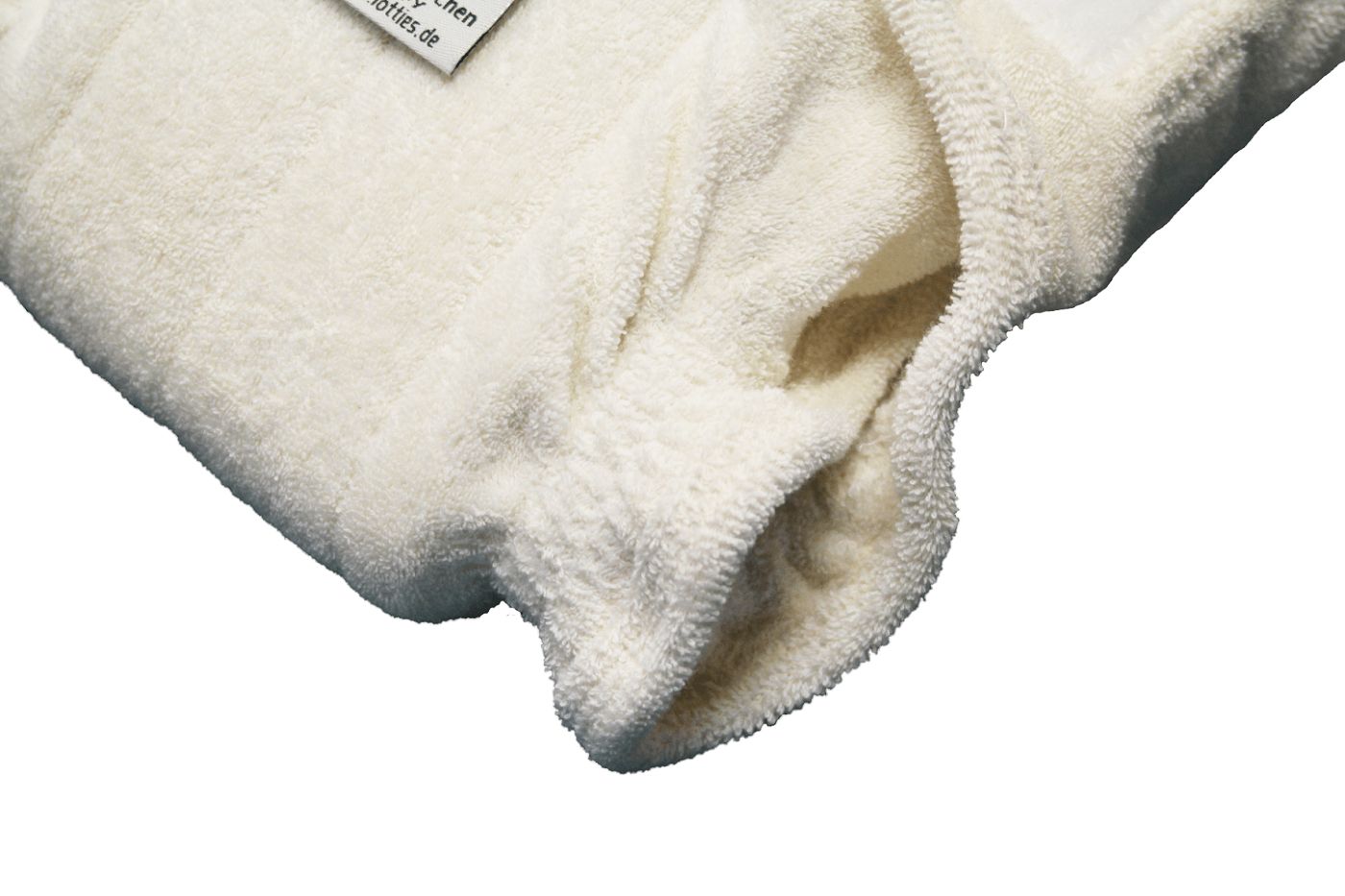 Nahaufnahme einer Windelhose aus weichem, cremefarbenem Stoff. Zeigt die weiche, saugfähige Innenseite.