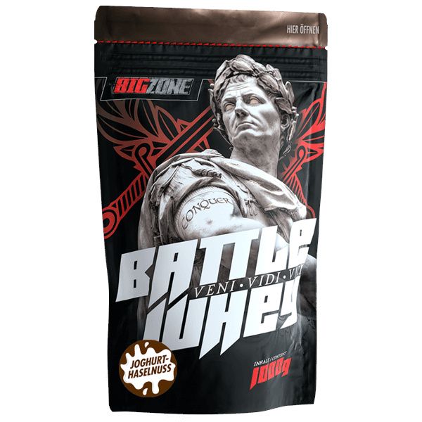 Beutel mit Big Zone Battle Whey. Abbildung einer Statue. Aufschrift: Joghurt-Haselnuss. Enthält 1000g.