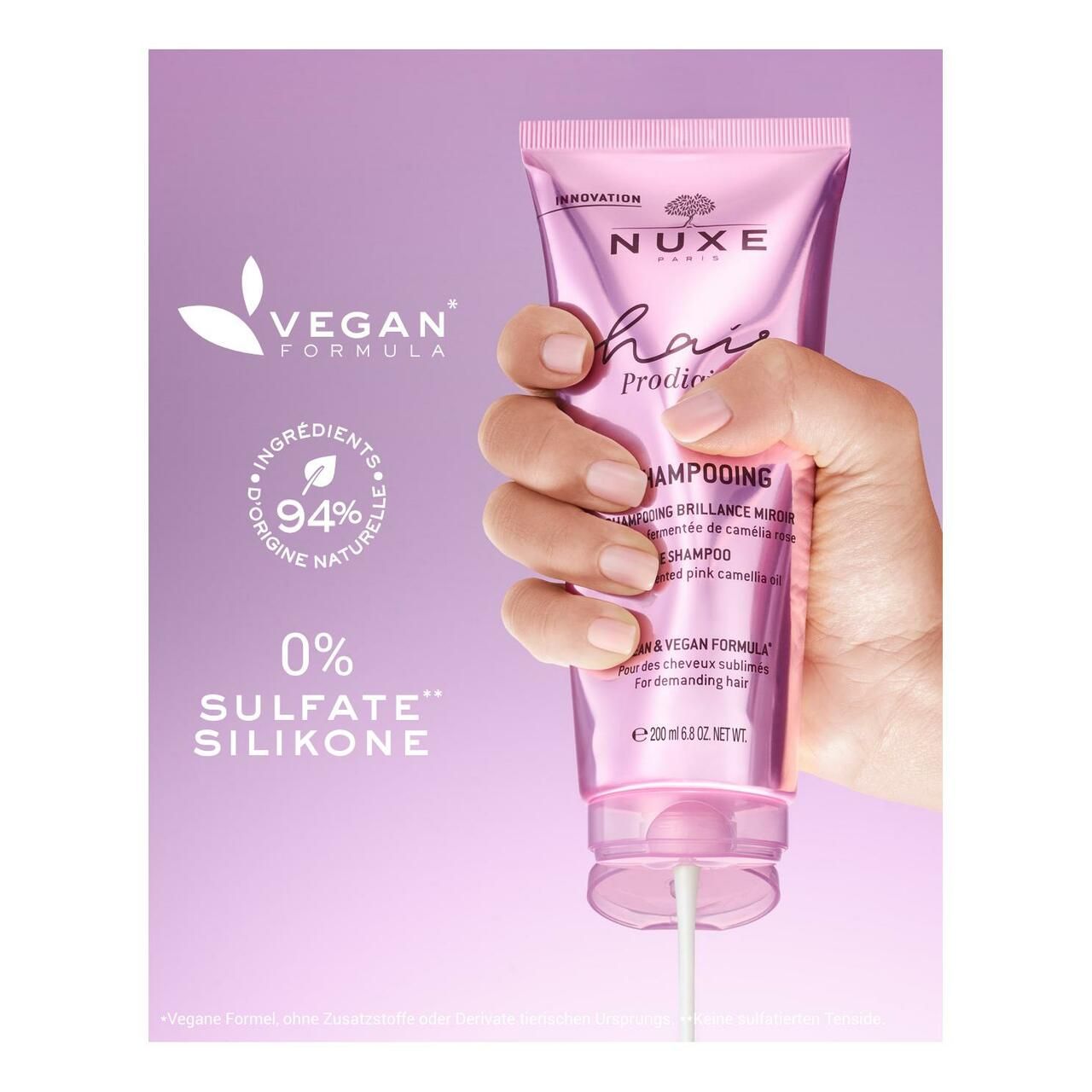 Hand hält eine Shampoo-Tube. Text: Vegan, 94% Inhaltsstoffe natürlichen Ursprungs, 0% Sulfate, Silikone.