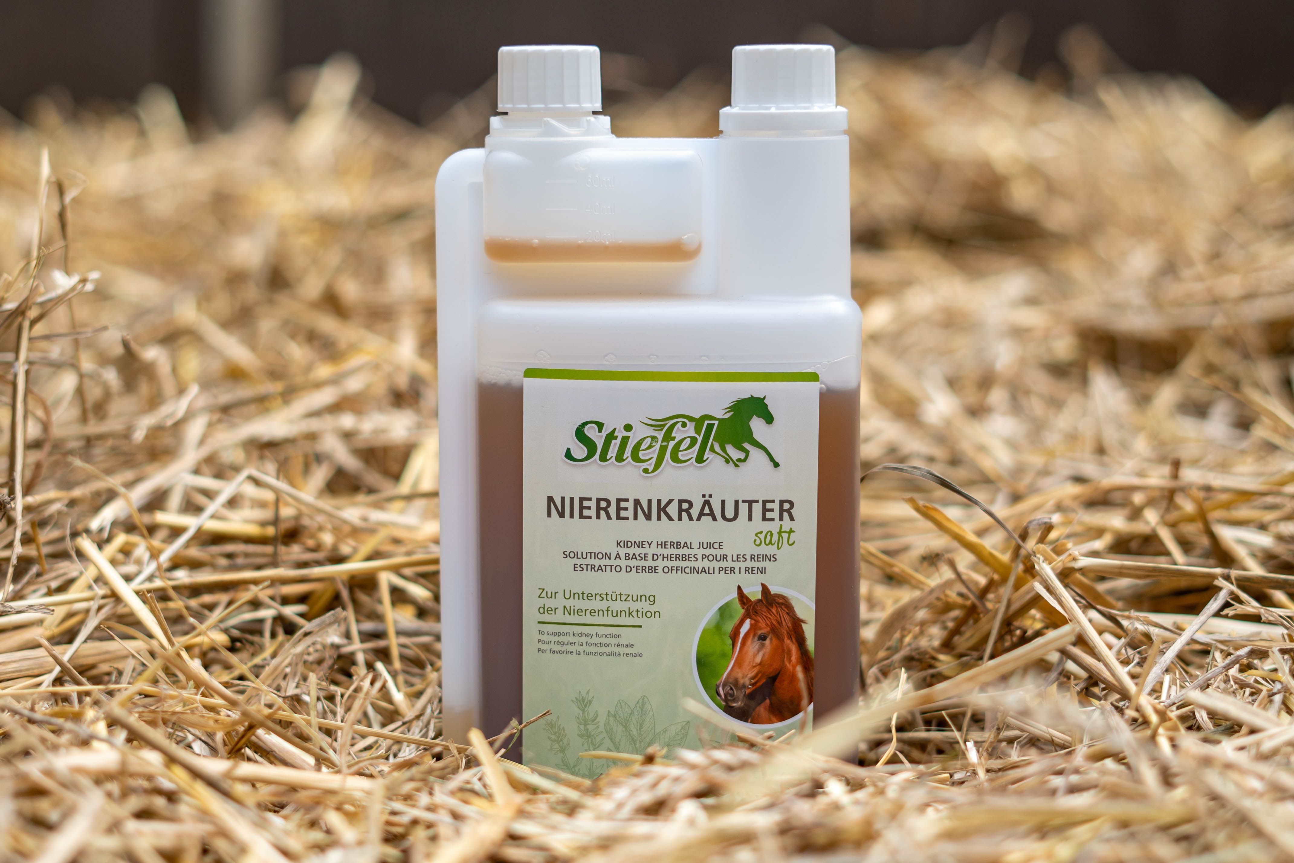 Kräutersaft-Flasche auf Stroh. Aufschrift: Stiefel Nierenkräuter Saft. Abbildung eines Pferdes. Flasche mit zwei Kammern.
