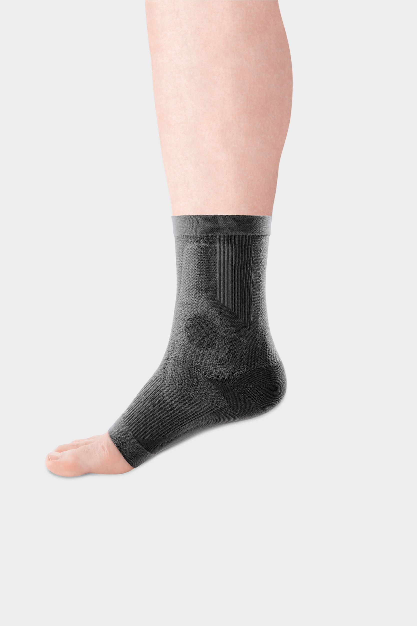 Graue JuzoFlex Malleo Xtra Anatomic Sprunggelenkbandage am Bein. Rippenmuster und anatomische Form. Keine Logos sichtbar.
