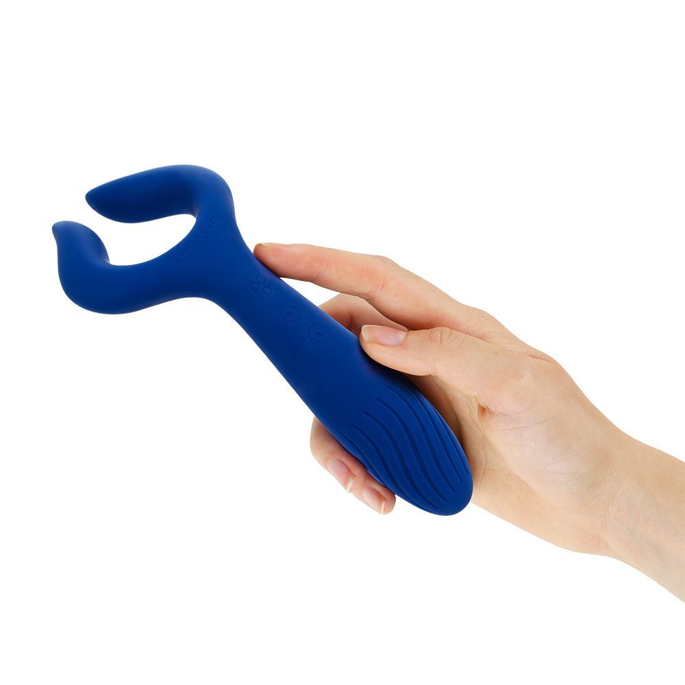 Blauer Paarvibrator in Hand gehalten. U-förmiges Design mit geriffelter Oberfläche am Griff.
