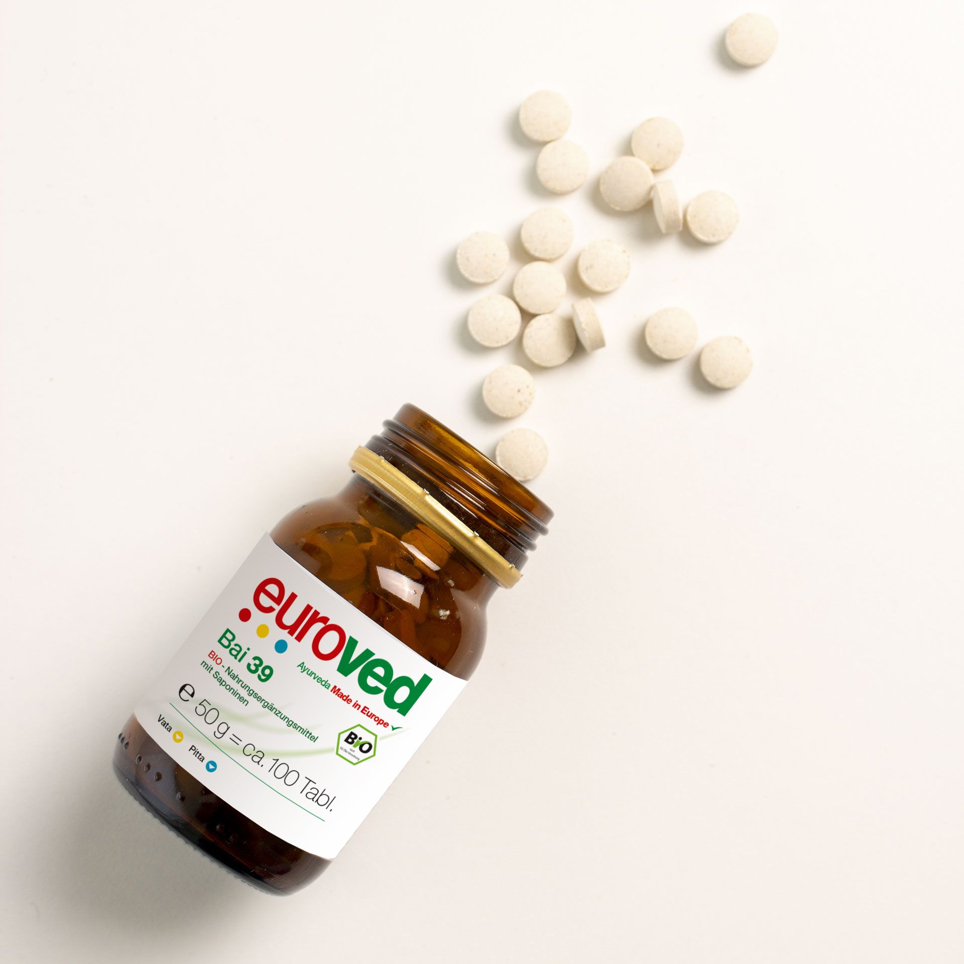 Braune Glasflasche mit Tabletten. Aufschrift euroved Bai 39. BIO-Siegel. Tabletten verstreut.