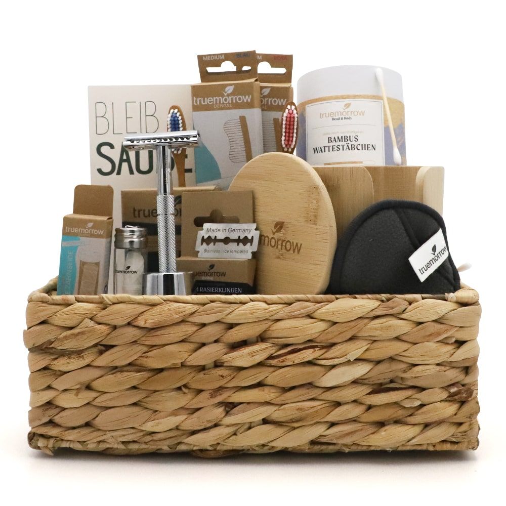 Geschenkset in einem Korb. Enthält Rasierer, Abschminkpads, Zahnbürsten, Wattepads, Rasierklingen und weitere Pflegeprodukte.