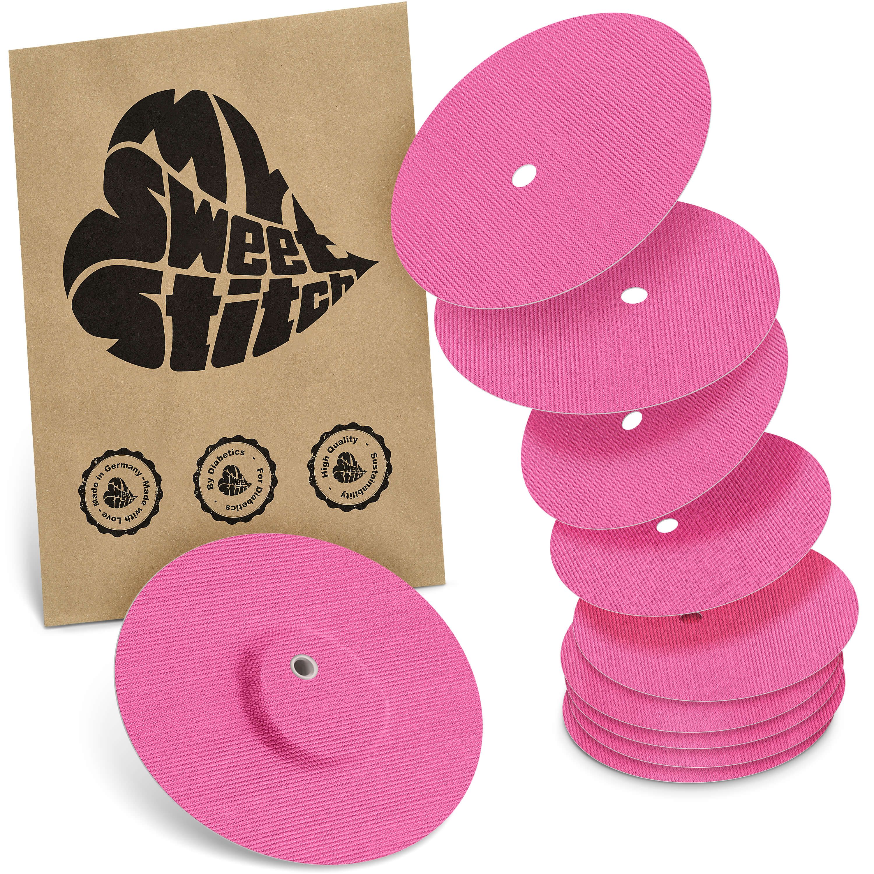 Rosa Pflaster, teilweise gestapelt, mit Loch. Braune Verpackung mit Logo und Qualitätssiegeln.