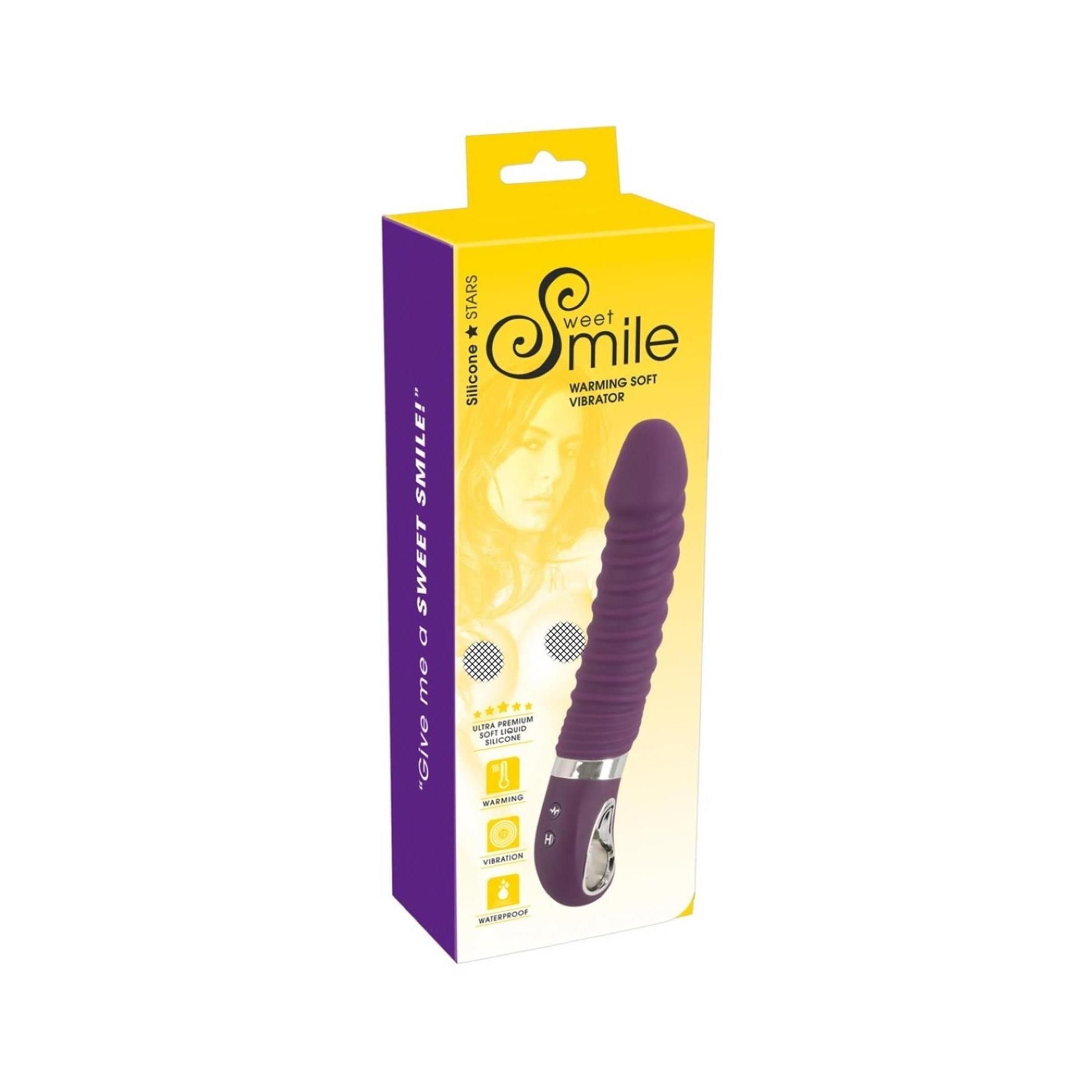 Lila Vibrator in Verpackung. Aufschrift: Sweet Smile, Warming Soft Vibrator. Verpackung mit Produktabbildung und Icons.