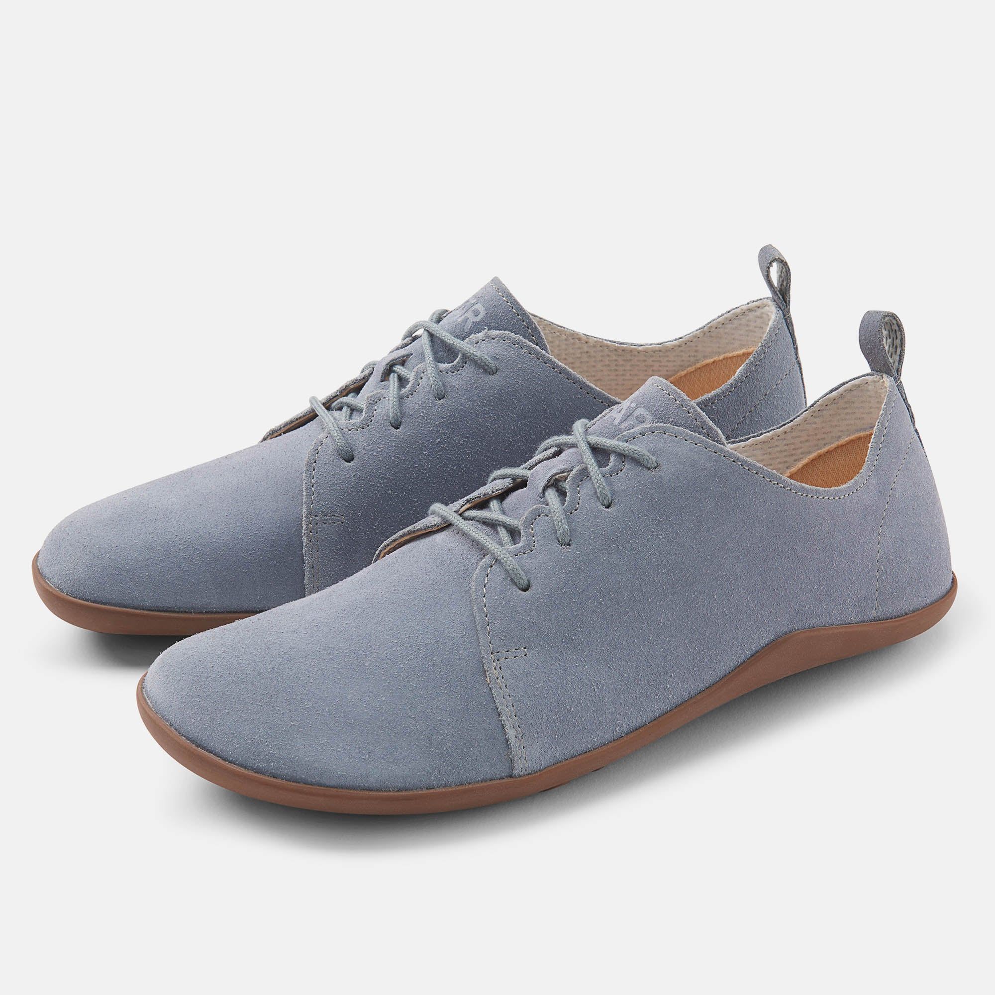 Hellblauer Schnürschuh mit brauner Sohle. Obermaterial aus Wildleder. Schuh leicht schräg gestellt.