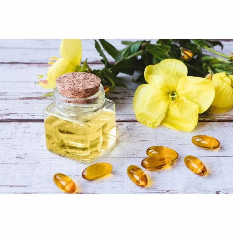 Glasflasche mit Öl und Kapseln. Gelbe Blüten und Blätter im Hintergrund. Korkenverschluss.
