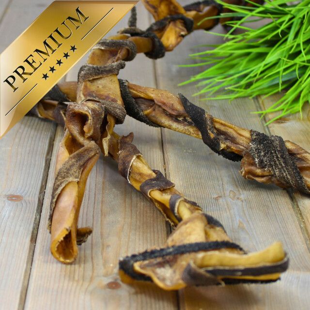 Zwei Lyra Pet Rinderkopfhautstangen mit Pansen auf Holz. Ein goldenes Premium-Etikett ist sichtbar.