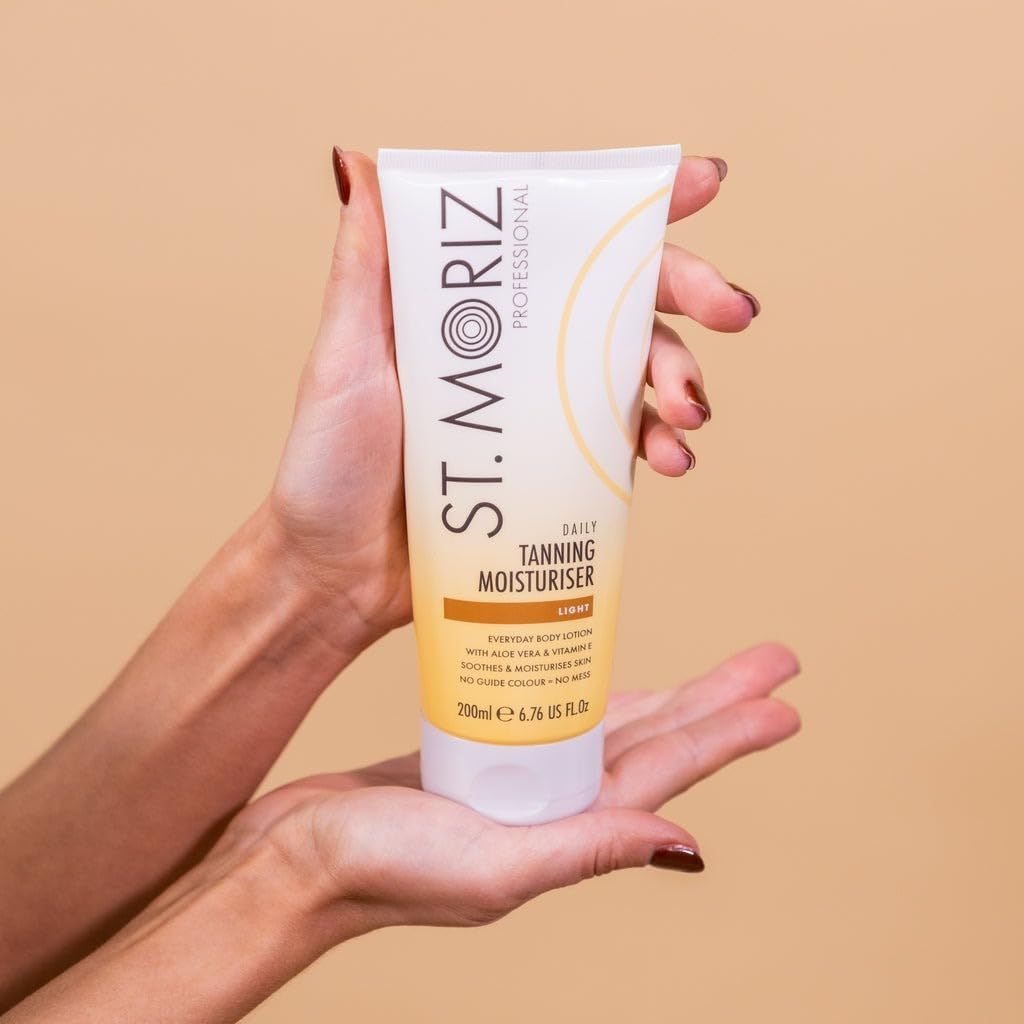 Hände halten St. Moriz Lotion. Weiße Tube mit gelben Akzenten. Aufschrift: Daily Tanning Moisturiser, Light.