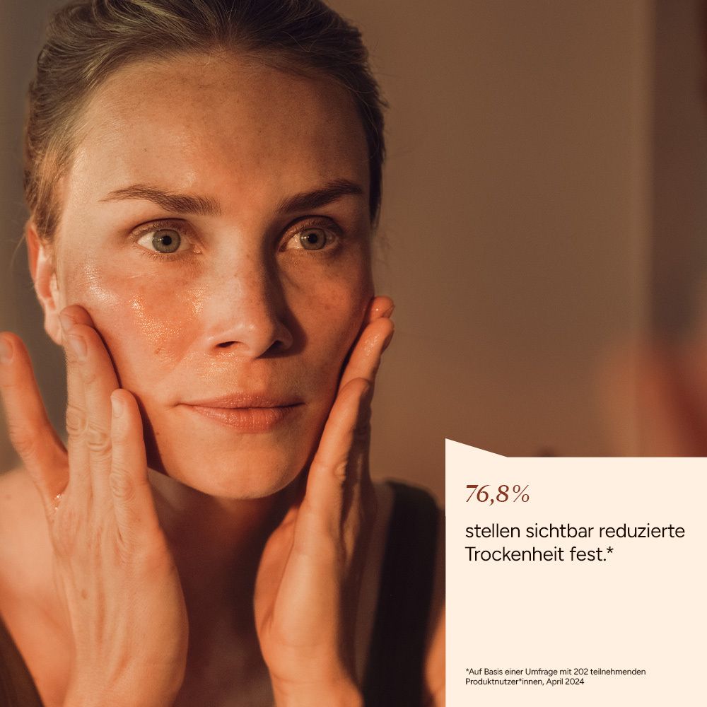 Frau im Spiegel, Gesicht mit Händen berührend. Text: 76,8% stellen sichtbar reduzierte Trockenheit fest.